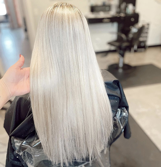 the back view of a person with long straight ash blonde hair